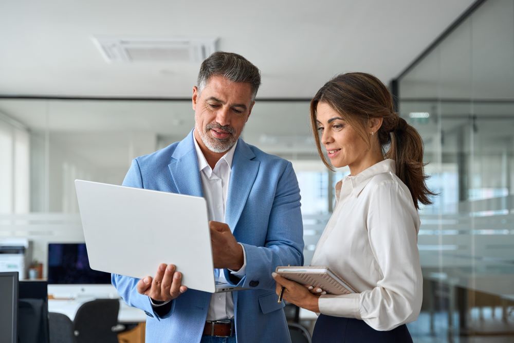 Smiling businessman and businesswoman having conversation at work